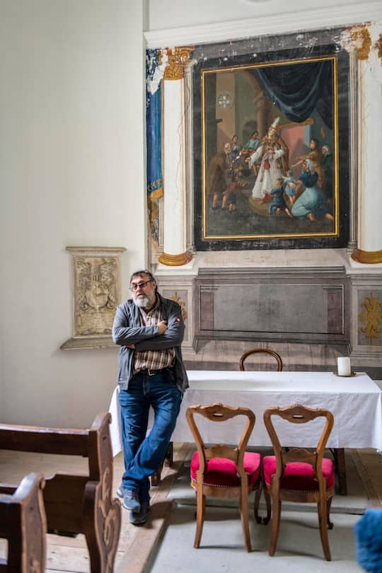 Gian-Battista von Tscharner lehnt an Tisch. Gemälde im Hintergrund