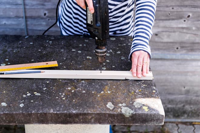 Sandra Dangel bohrt mit Bohrer auf Holzleiste